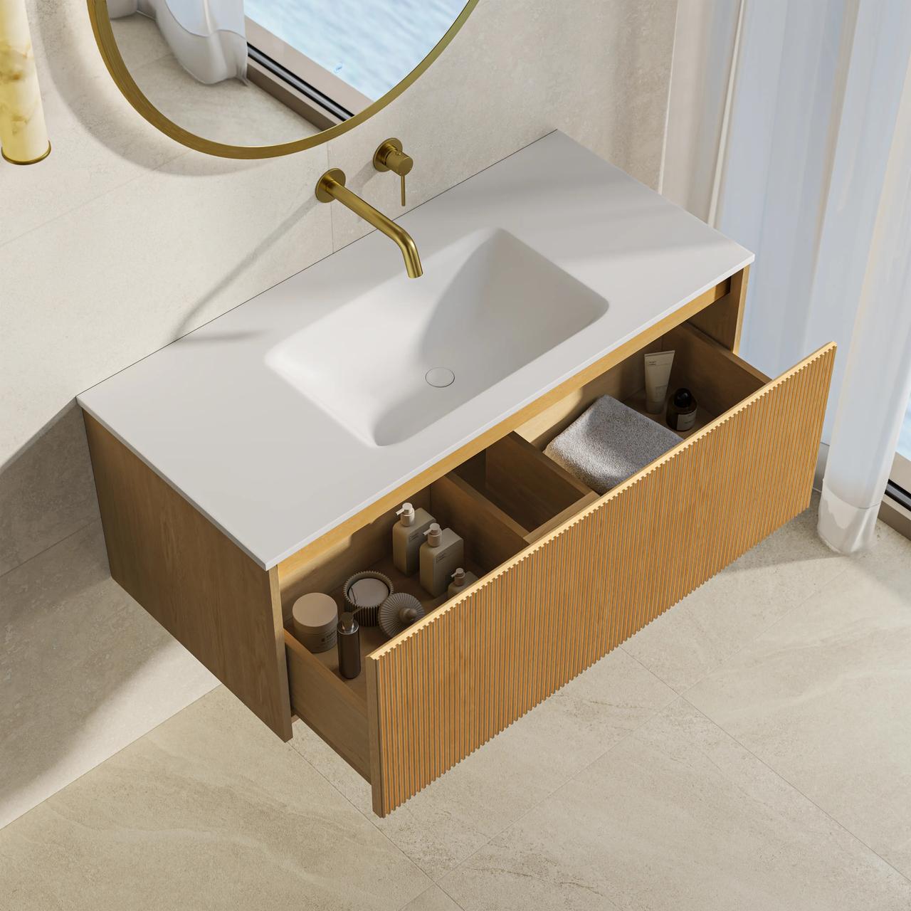A top-down view of a modern 3d bathroom vanity featuring a ribbed light wood cabinet and an integrated white sink. The main drawer is pulled open to reveal organized toiletries, complemented by a wall-mounted gold faucet and a round mirror.