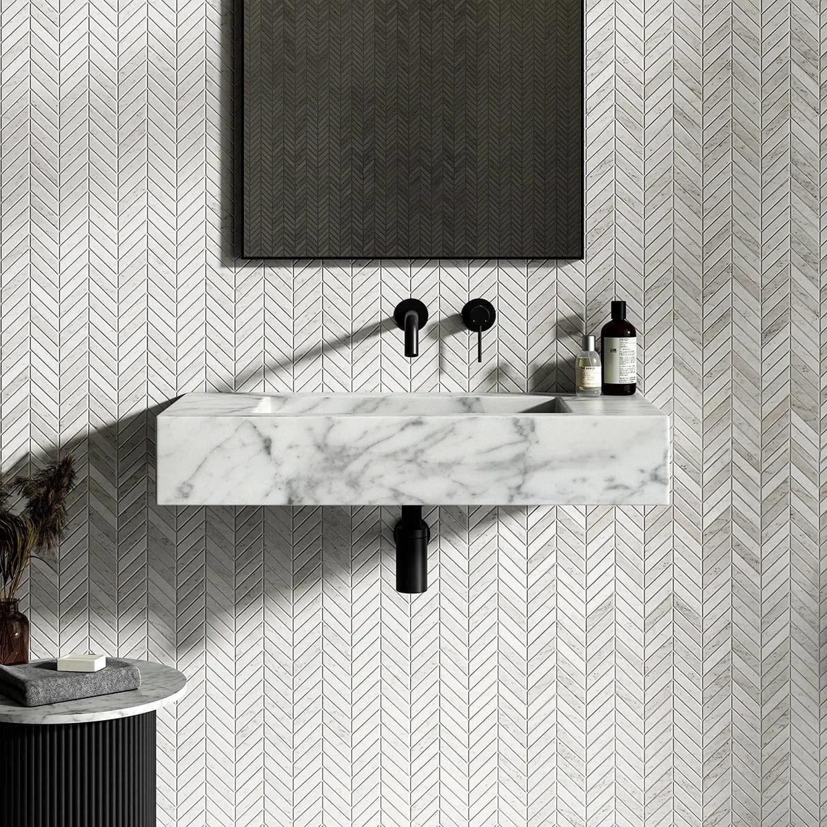 A modern bathroom setup featuring a floating white marble sink and matte black wall-mounted fixtures against a chevron tile wall, showcasing high-end 3d bathroom rendering.