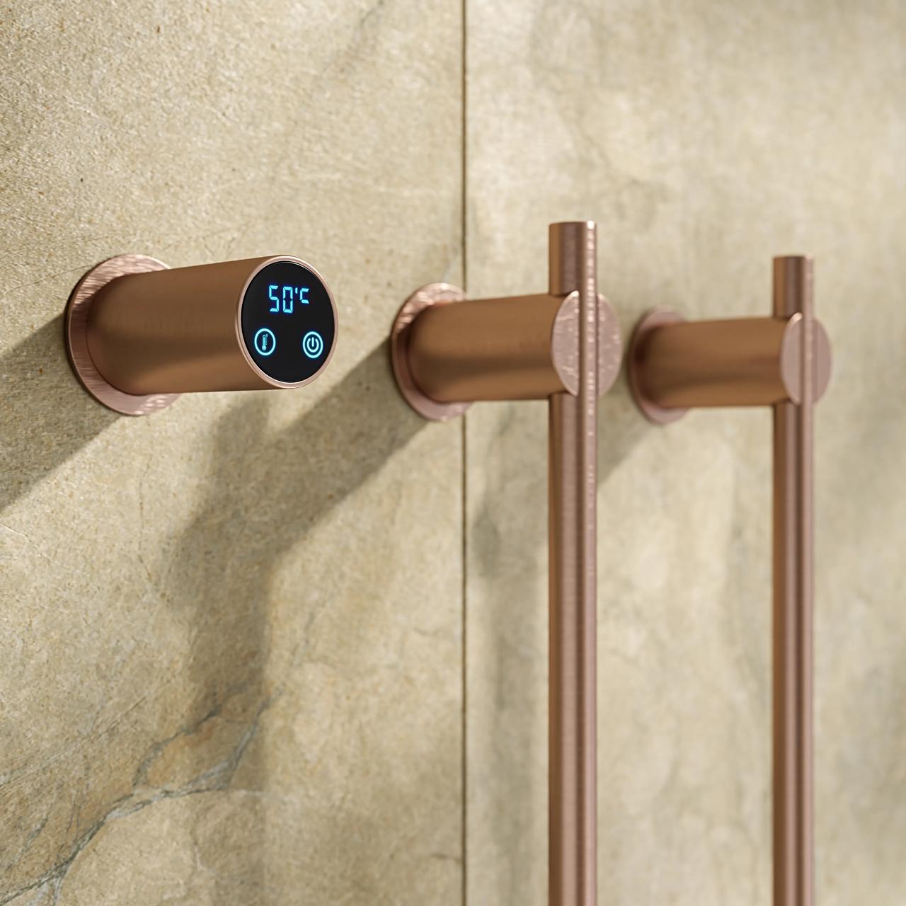 A detailed close-up shot of a 3d modern vertical electric towel warmer in a brushed rose gold finish. The setup features a round digital controller displaying 50°C alongside two sleek vertical heating bars mounted on a warm beige stone tile wall.