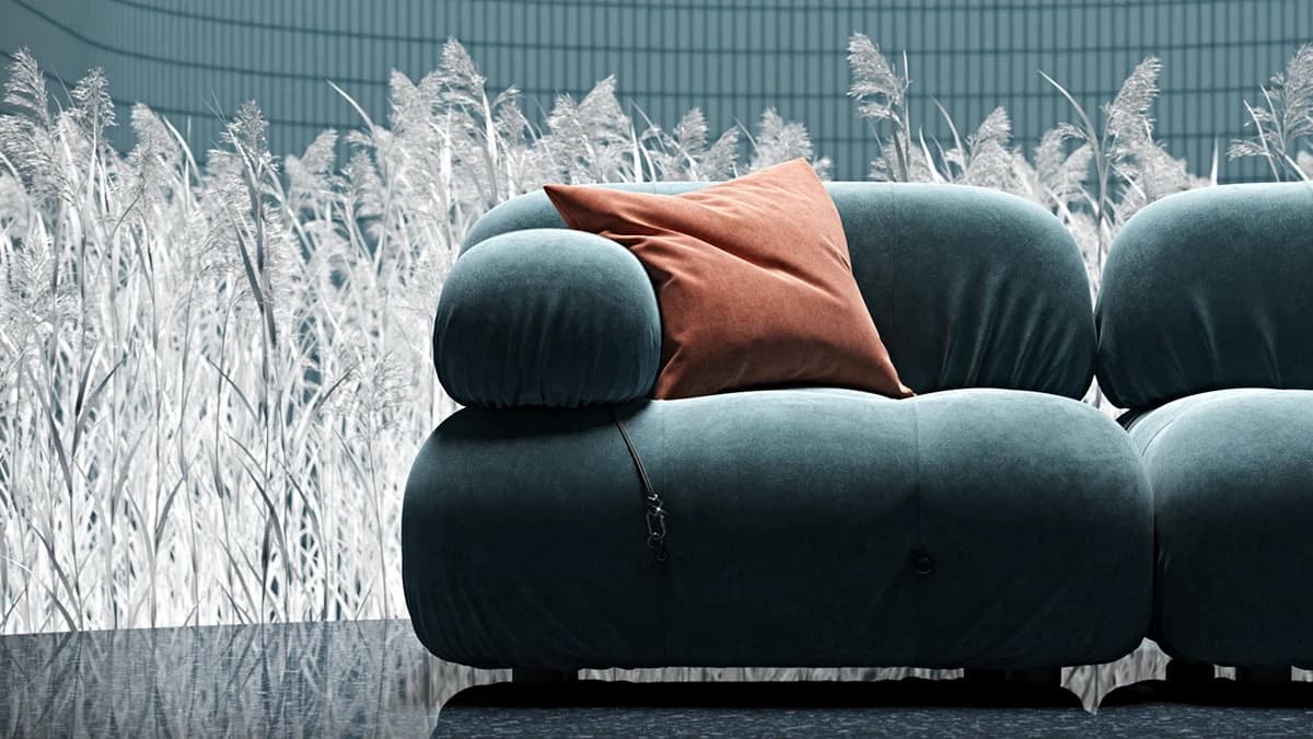 Artistic 3d visualization of a teal velvet modular sofa with a terrace-orange cushion set against a surreal monochrome reed backdrop.