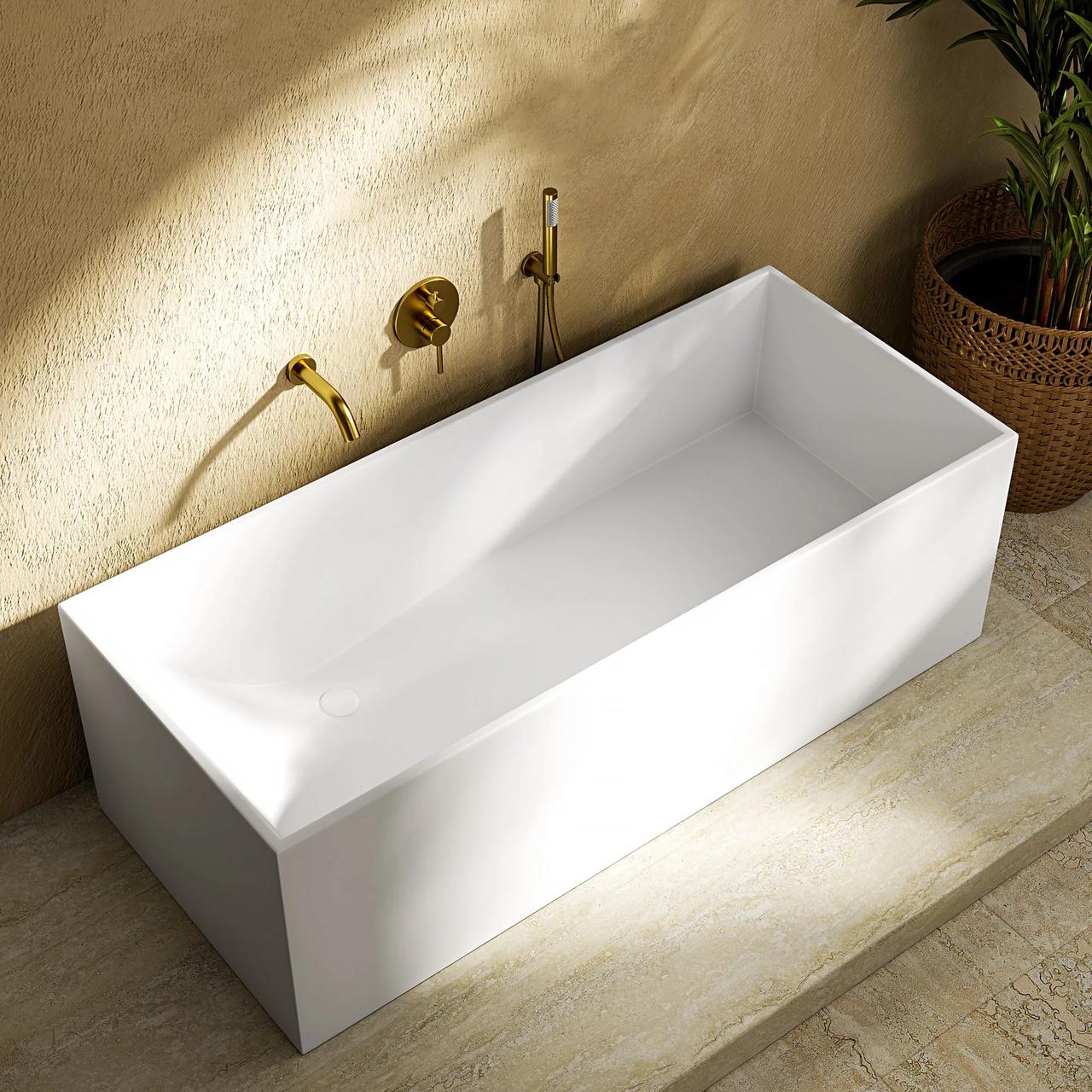 A top-down view of a minimalist bathroom bathed in warm sunlight. A sharp, rectangular white freestanding bathtub sits on a light marble floor against a textured beige wall. Wall-mounted brass faucets cast crisp shadows onto the tub, and a potted plant in a woven basket sits in the top right corner.