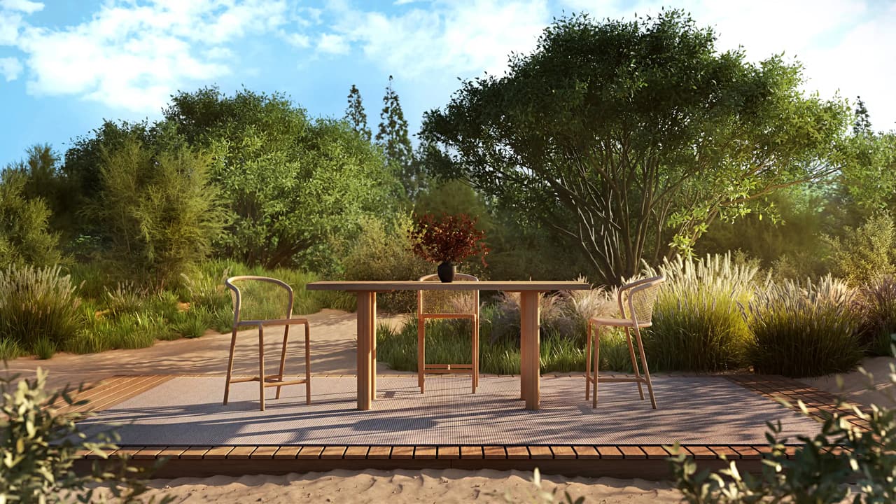 A photorealistic 3D exterior render of a tall wooden outdoor bar table with three woven bar stools set on a patio rug. The set is positioned on a wooden deck amid sandy soil, tall grasses, and lush trees under bright natural sunlight.