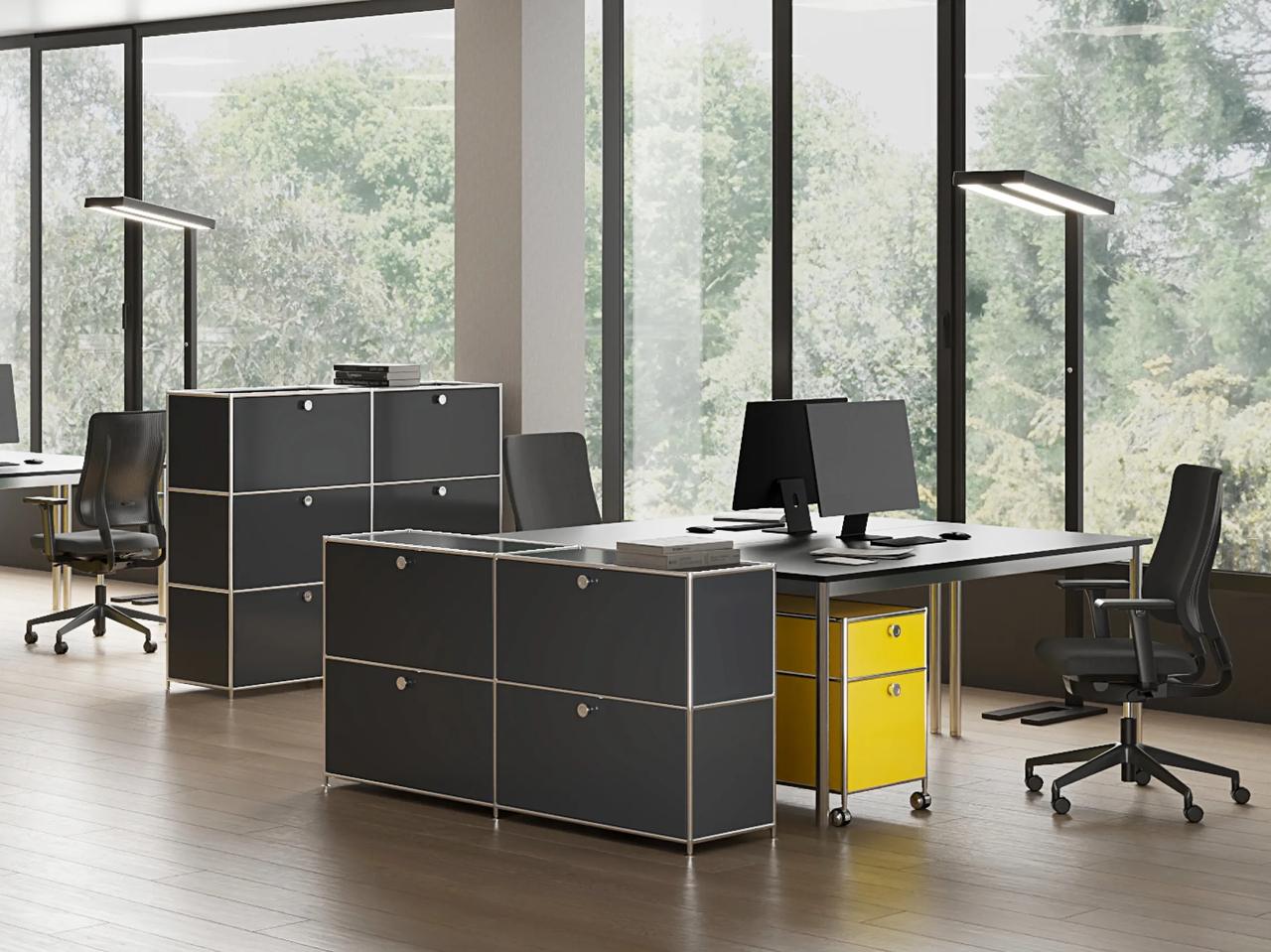 A bright office interior featuring black storage units with chrome frames.