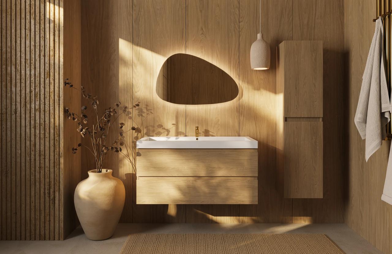 Modern bathroom interior featuring a floating wooden vanity with a white basin, an organically shaped illuminated mirror, and warm sunlight casting soft shadows on wooden wall panels
