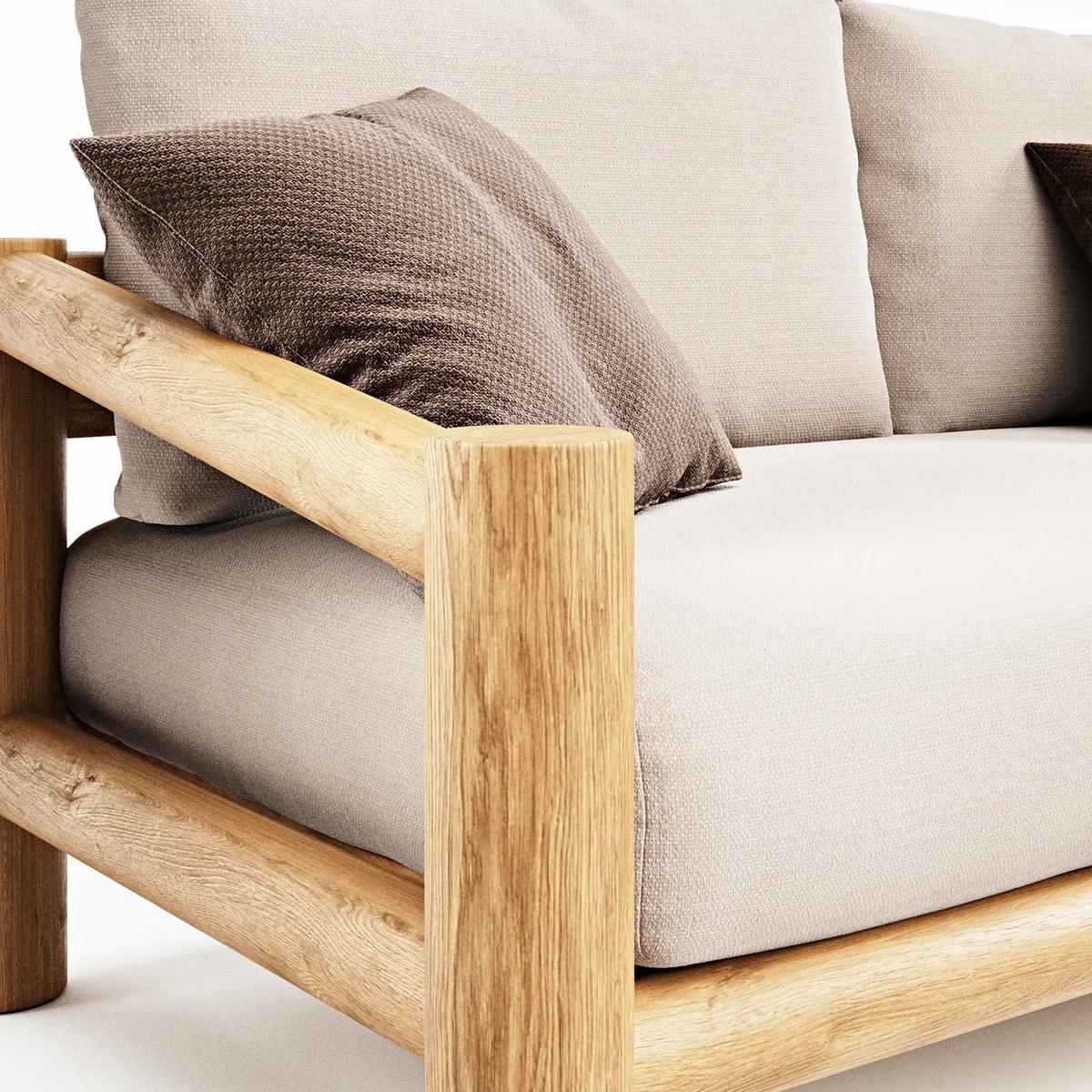 A macro studio shot of a modern sofa corner, highlighting the rounded light wood frame, thick beige upholstered seating, and a textured brown throw pillow against a white background.