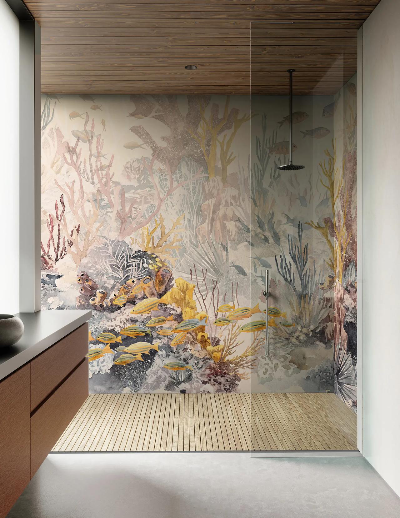 A glass-enclosed cgi walk-in shower is highlighted by a striking underwater coral reef mural on the back wall. The space features a warm wooden ceiling, a matching slatted wood floor, and a sleek black ceiling-mounted showerhead, with natural light pouring in from the left.