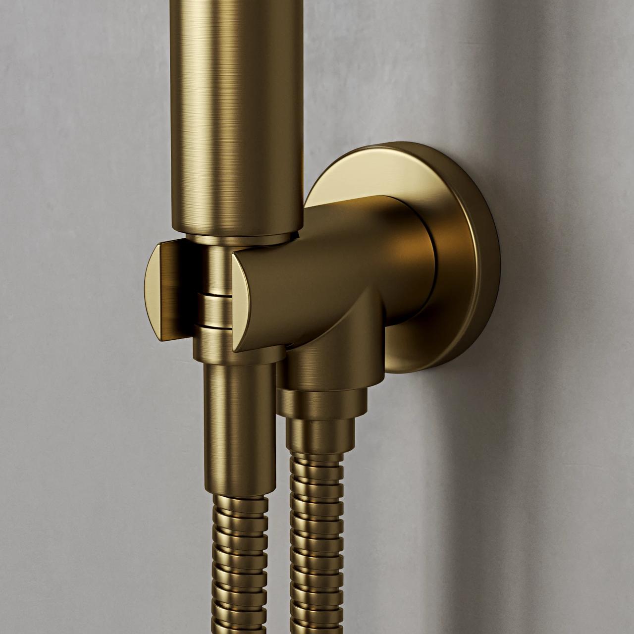 A macro close-up shot of a cylindrical brushed 3d brass handheld shower resting in a matching circular wall bracket. A ribbed metallic shower hose extends downwards from the fixture. The metal features a realistic brushed texture with soft highlights, set against a simple, light grey wall background.