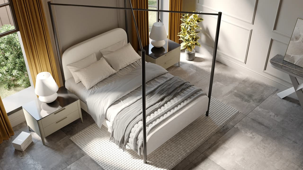 A top-down view of a bright modern cgi bedroom featuring a black metal four-poster bed frame with a white upholstered base and textured grey throws. The bed sits on a light woven rug and is flanked by two sleek nightstands with white mushroom-shaped lamps, all bathed in warm natural light.