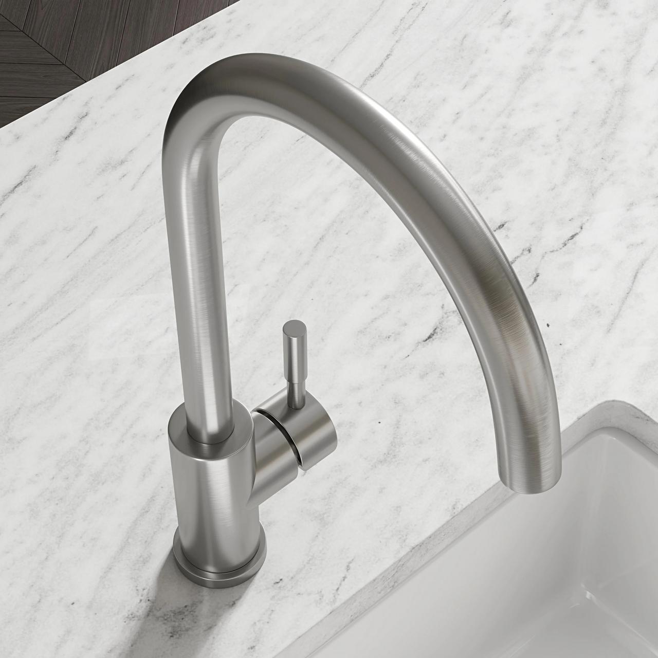 A close-up, high-angle view of a modern curved brushed steel kitchen faucet on a white marble countertop, highlighting highly detailed 3d product rendering.