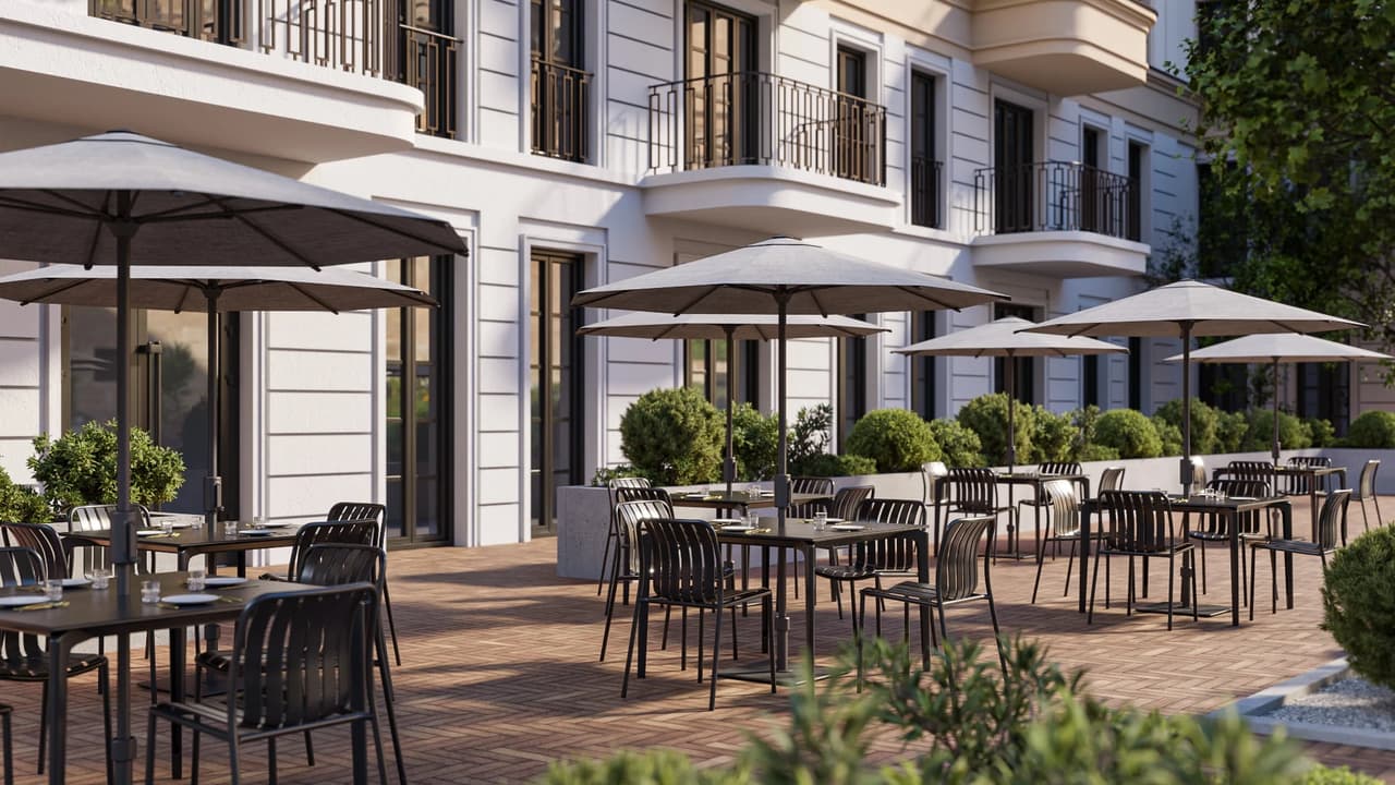 A bustling cgi outdoor patio of a classic European-style building, lined with multiple dining tables, black metal chairs, and large silver-grey umbrellas. The sunlit terrace features neat greenery planters and polished paved flooring, extending into a deep perspective.